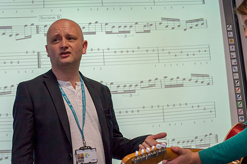 Ian Dyball with guitar students at a University Campus Suffolk music lecture